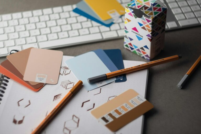 Bureau de designer avec un nuancier de couleurs et codes hexadécimaux, illustrant la création d'un kit de marques